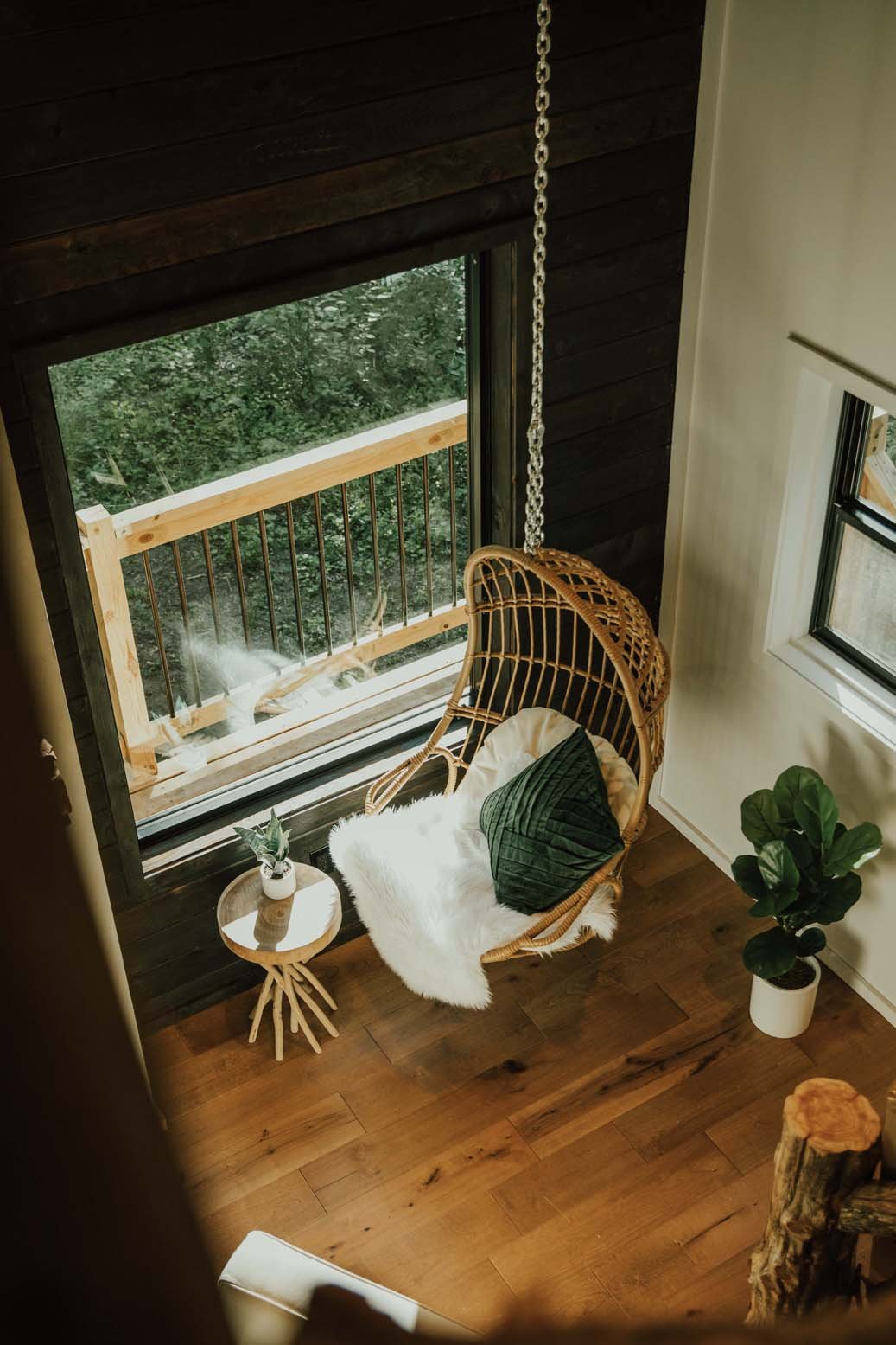 boho swing chair in living room next to large window