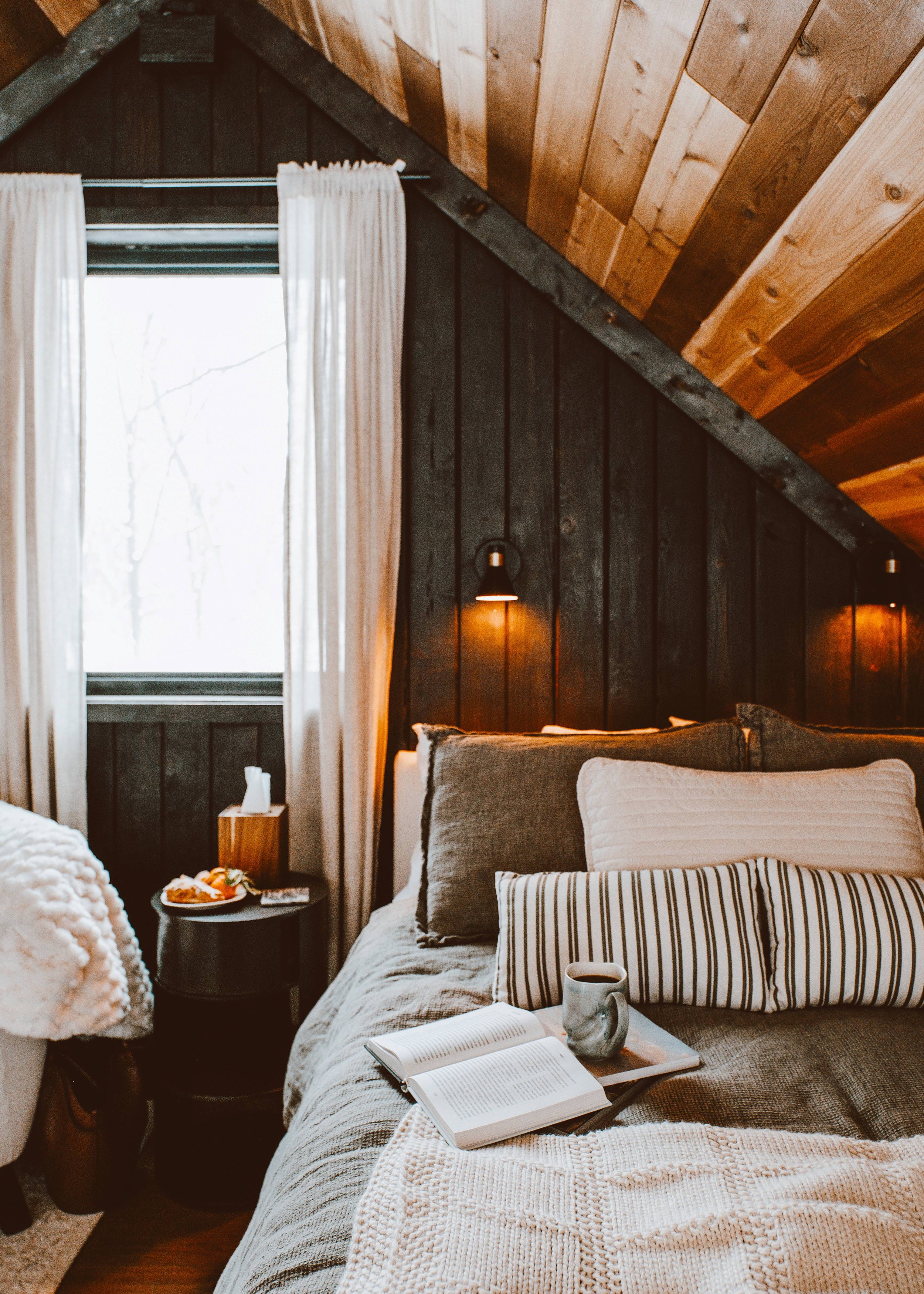 cozy loft bedroom with shou sugi ban black cedar wood wall and cozy bed