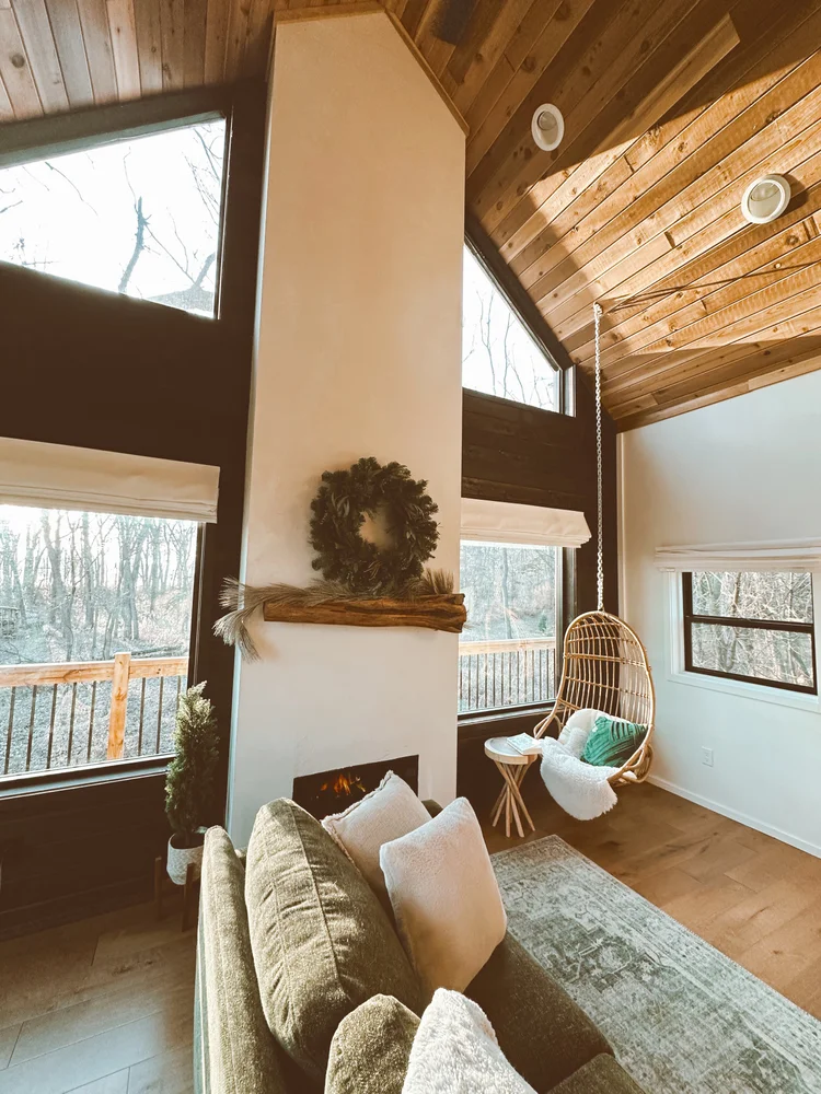 treehouse living room with dark accent wall and fireplace with swinging chair